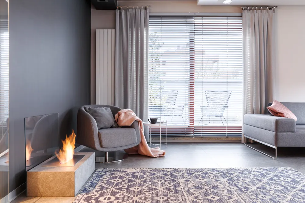 Modern living room with grey lounge, venetian blinds and patterned rug - Whitehouse Furnishers, Katherine