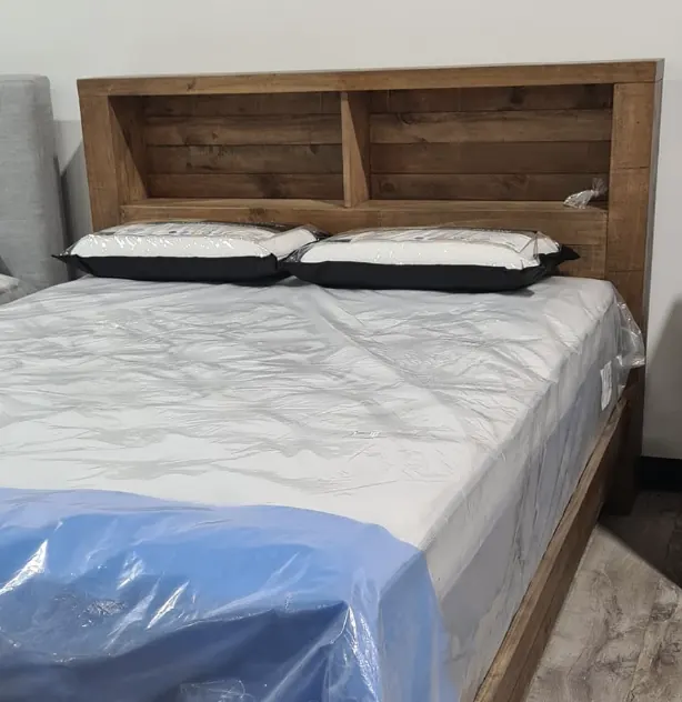 Rustic timber bookcase bed frame with a new mattress and pillows in the Whitehouse Furnishers Katherine showroom