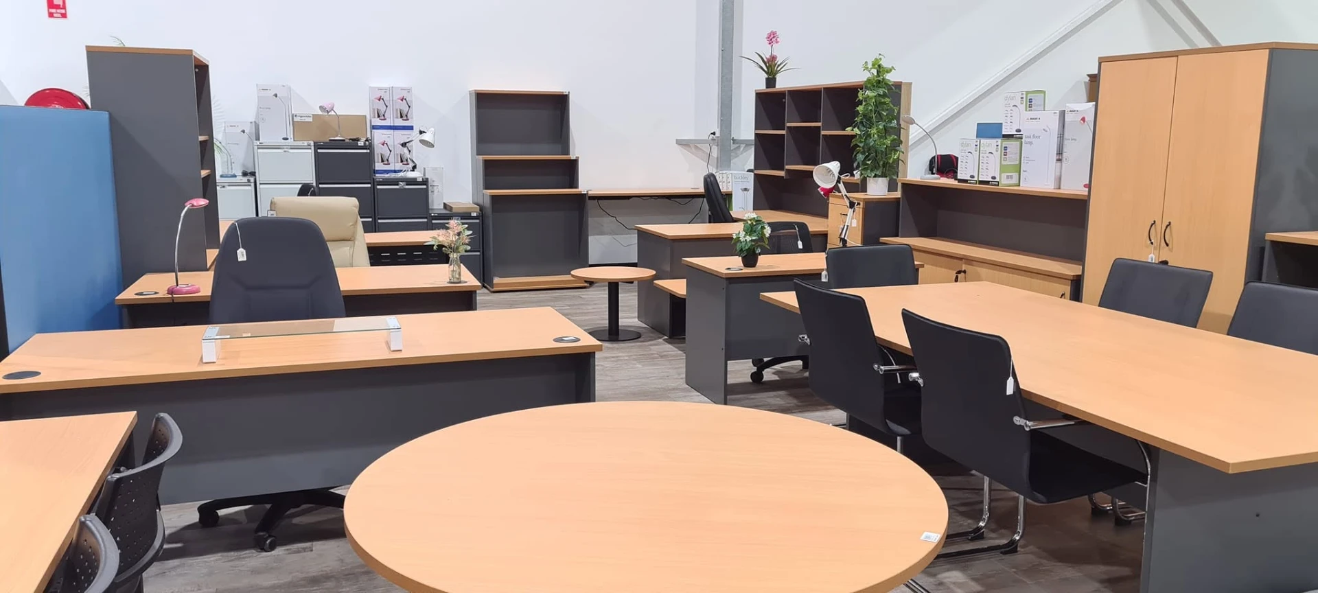Office desks, meeting table, ergonomic chairs and storage cabinets on display in the Whitehouse Furnishers Katherine office furniture showroom