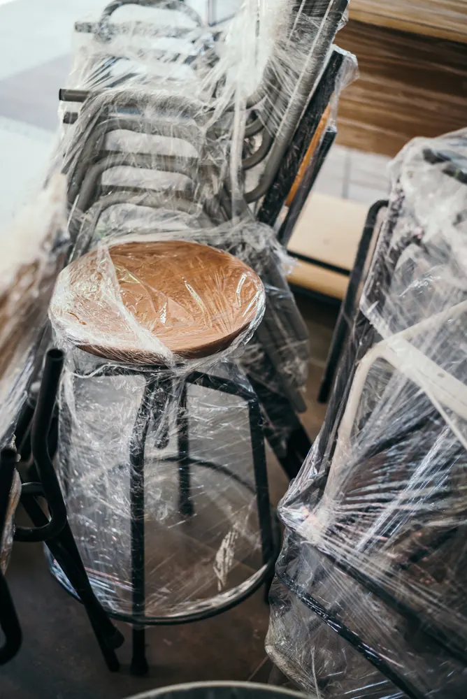 Chairs and furniture wrapped in protective plastic ready for safe transport - Whitehouse Furnishers, Katherine